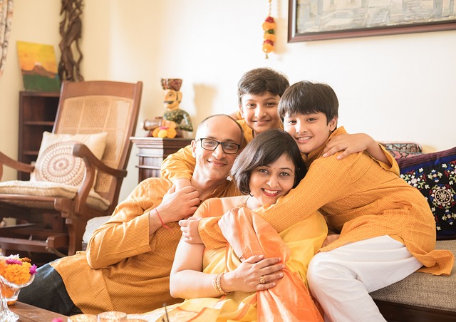 A family of four posing together in yellow traditional clothes