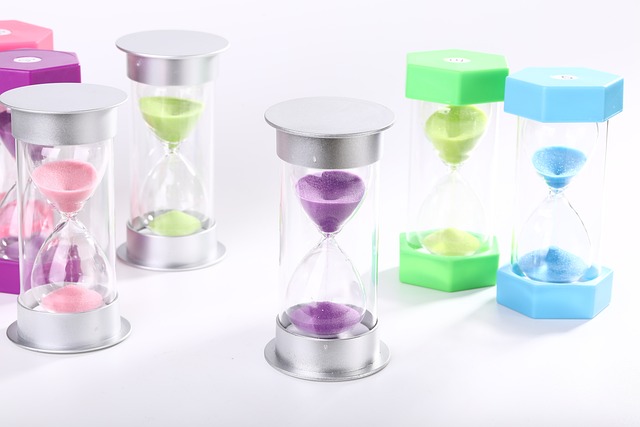 Multiple colorful hourglass sand timers on a white background