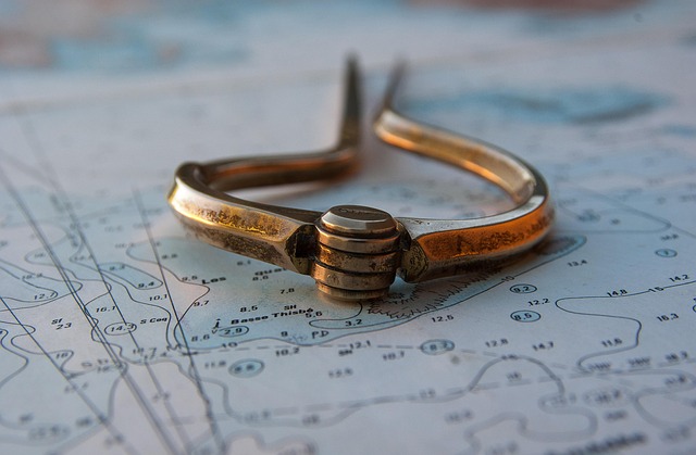 A brass navigational divider resting on a nautical map