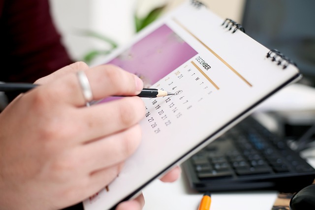 Person circling a date on a desk calendar with a pencil