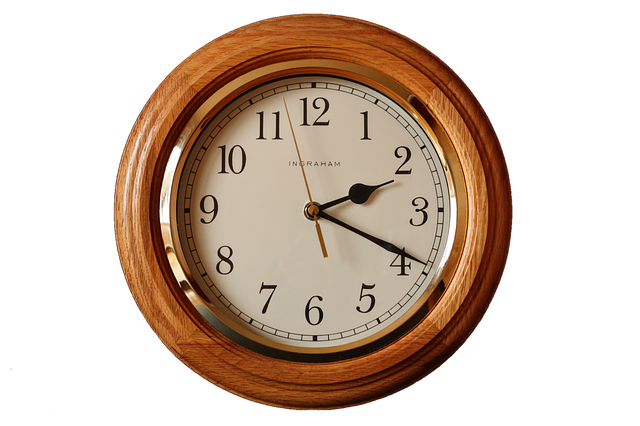 A round wooden wall clock with black numbers and hands
