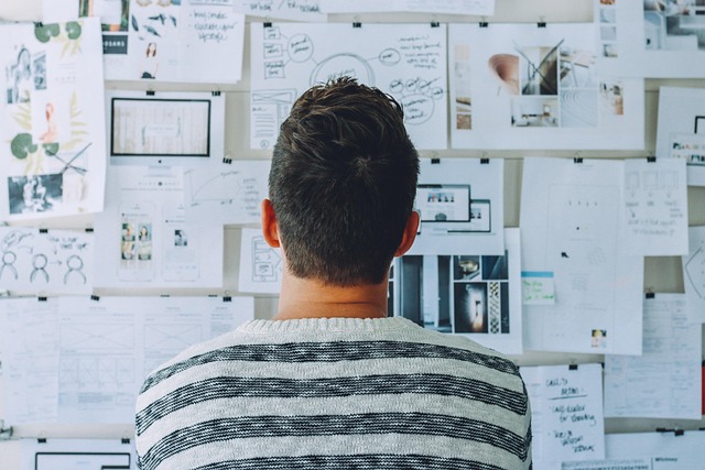 A person looking at a wall covered with strategy and planning papers