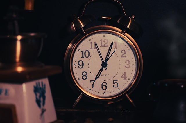A vintage metal alarm clock on a dark surface