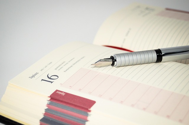 An open daily planner calendar with a fountain pen