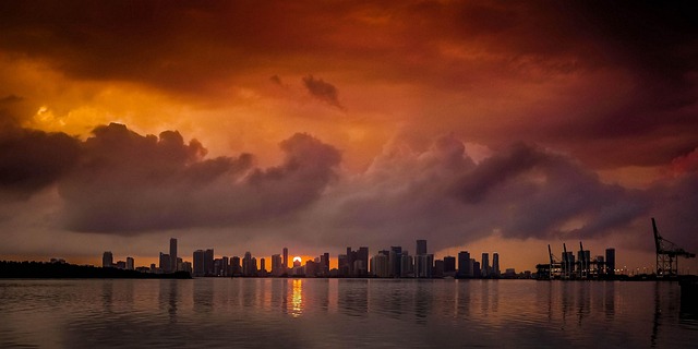 Miami skyline with dramatic orange sunset clouds reflecting over water