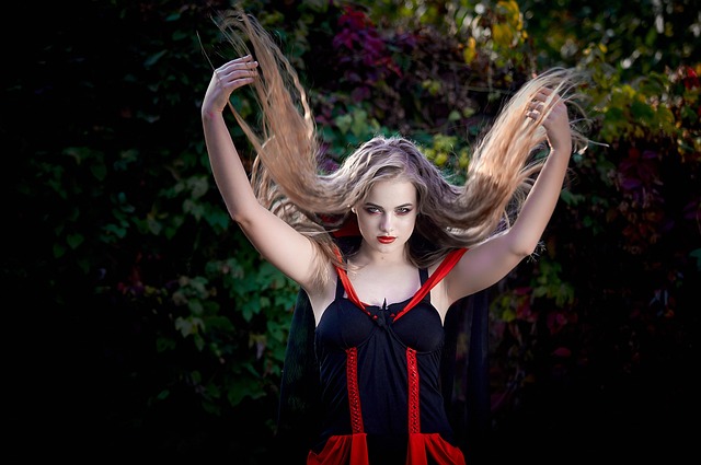 A woman in a vampire costume tossing her long hair